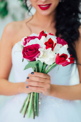 Obraz na płótnie Canvas nice wedding bouquet with red flowers in bride's hands . 