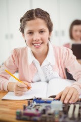 Schoolgirl working on electronic project in classroom