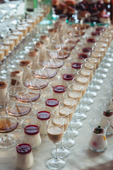 Beautiful row line of different colored alcohol cocktails on a party, Whisky cognac, liquor.