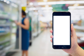 Woman hold mobile phone while shopping in supermarket