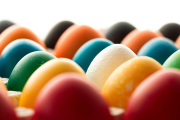 Multicolored Easter eggs, in a tray with one white egg. The concept of a holiday and a happy Easter.