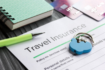 Traveling concept with insurance application on wooden table