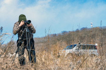 Photographer man taking pictures of animals in the wild