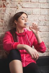 Young woman drinking water. Studio shot.