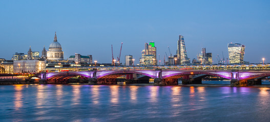 Fototapeta na wymiar London skyline at night with lights reflecting from the Thames River.
