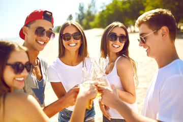 Group of friends hanging out with beer at the beach.  Excellent sunny weather. Beautiful figures. Super mood. Summer concept
