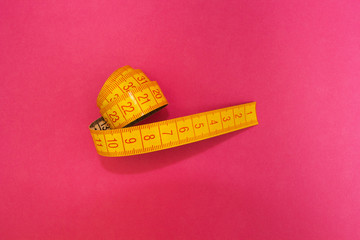 Measuring tape isolated on a pink background, diet.