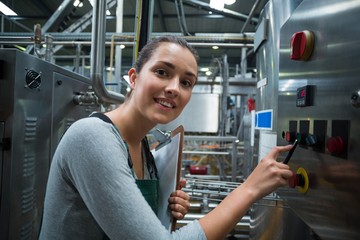 Female factory worker operating machine