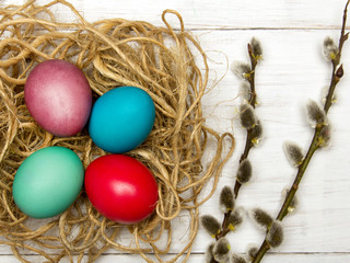 Easter background with eggs, nest and catkins on wooden background, copy space