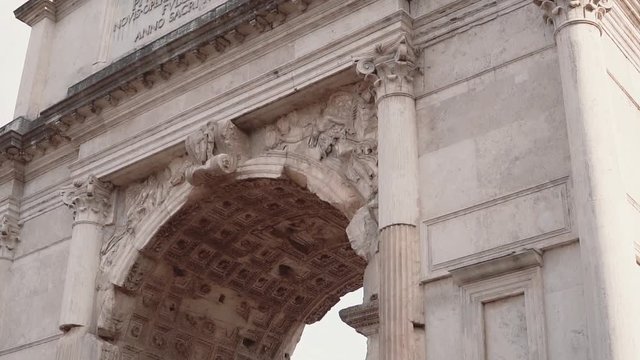 Close-up view of the Arch of Titus in Rome, Italy. Camera moving down.