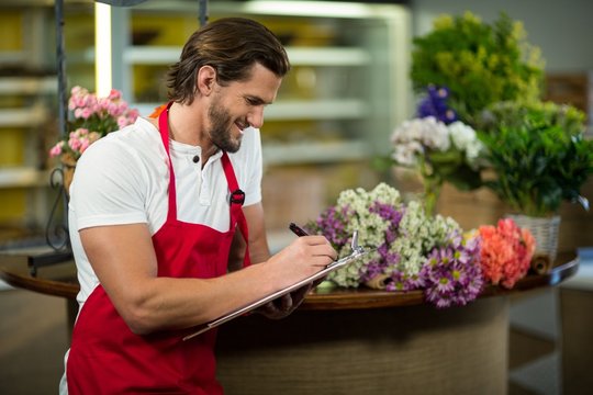 Florist writing on the clipboard