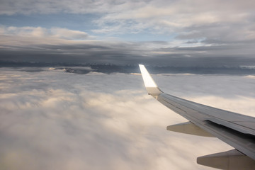 Obraz premium Wing of an aircraft and clouds and mountains