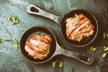 Two iron pan with fried wrapped bacon chicken. Top view. Toning