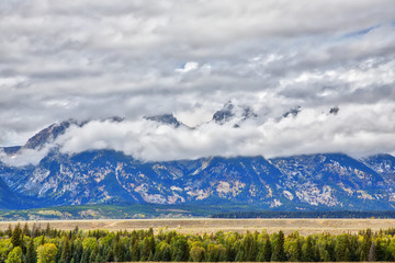 Fototapeta premium Clouds moving in to cover the Teton Mountain range.