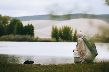 Jesus Christ thinking next to a body of water
