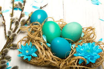Easter background with eggs, nest and catkinson white wooden background, copy space