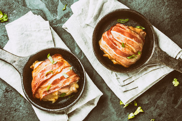 Two iron pan with fried wrapped bacon chicken. Top view. Toning