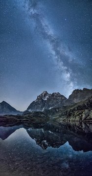 Scenic view of Monte Viso mountain and milky way reflecting in lake