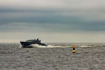 Black elite speed motor boat moving fast from Baltic sea