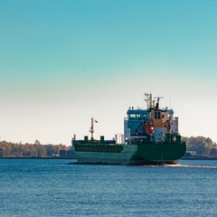 Fototapeta premium Green cargo ship entering a port of Riga, Europe