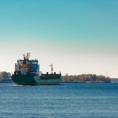 Naklejka premium Green cargo ship entering a port of Riga, Europe