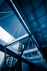 Bottom view of modern skyscrapers in business district against blue sky