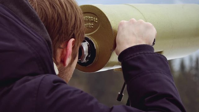 Man looking mountain through monocular binocular on tv tower
