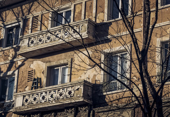 Old house wall with windows and balconies in sunny day