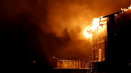 House building on fire at night. Inferno conflagration.