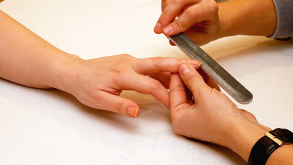 Obraz na płótnie Canvas Manicure in the beauty salon. Painting and polishing nails. Spa nails cuticle scarfskin procedure.