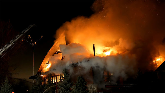 House building on fire at night. Inferno conflagration.