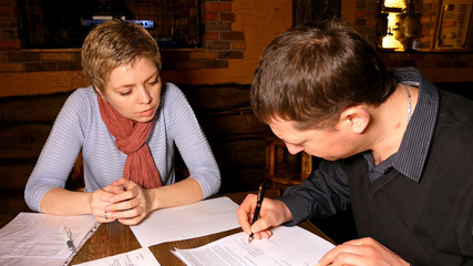 Fototapeta na wymiar Businessman and businesswoman business partners discussing and signing contract in a restaurant cafe.