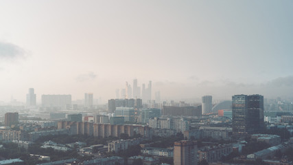Fototapeta na wymiar Hazy early morning metropolitan cityscape view from high point: residential and office buildings, 