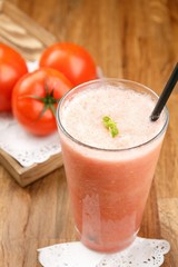 Tomato juice in clear glass on wooden table 
