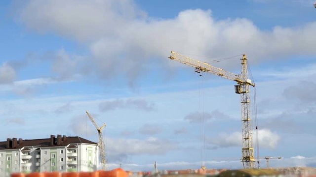 Large construction cranes work at construction site of dwelling complex. Timelapse