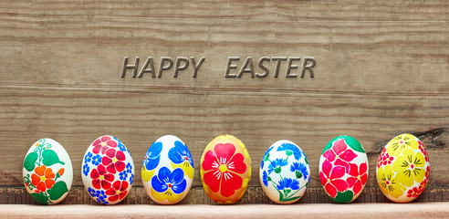 Easter eggs with a hand-drawn floral pattern on a wooden background