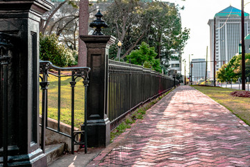 Black wrought iron fence next to sidewalk