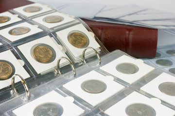 Coins in the album. Selective focus. - obrazy, fototapety, plakaty