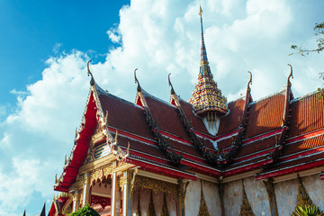 Fototapeta premium The tower of the temple. View to the temple and the tower under cloudy sky. Horizontal outdoors shot.