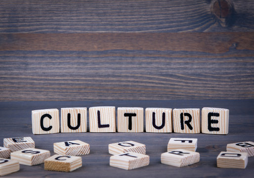 Culture word written on wood block. Dark wood background with texture.