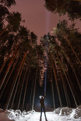 Man with flashlight in forest