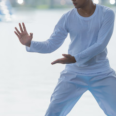 oung man practicing Tai Chi or Tai qi in the morning at the park for healthy, Tai Chi concept.