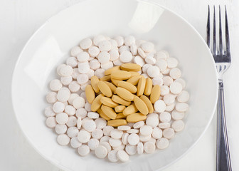 Plate with pills and fork. Medical and diet concept. View from above