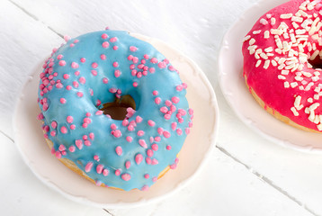 Plate with glazed donuts on white background
