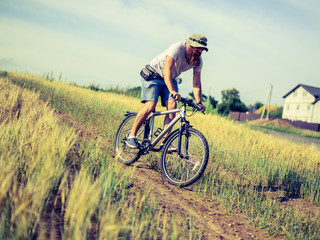 Fototapeta premium hipster man on a bicycle in the countryside