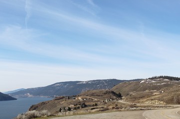 Early springtime mountain and lake landscape with houses on hillside.