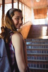 Portrait of schoolgirl to schoolbag standing near staircase