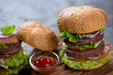 Close-up of double burger with beef cutlets and vegetables, selective focus