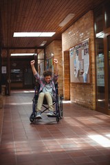 Disabled schoolboy on wheelchair in corridor at school