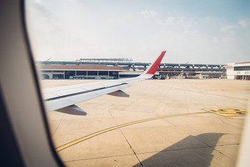 Wing of the plane on runway in airport.